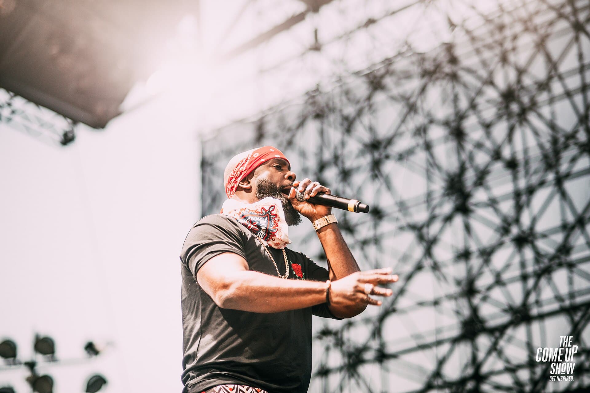 Bunji Garlin in a bandana and dark T-shirt singing into a microphone on stage at OVO Fest 2017 in Toronto